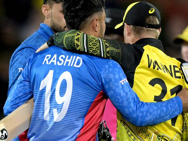 Australia's David Warner (R) embraces Afghanistan's Rashid Khan after the ICC men's Twenty20 World Cup 2022 cricket match between Australia and Afghanistan at Adelaide Oval on November 4, 2022 in Adelaide. (Photo by Brenton EDWARDS / AFP) / -- IMAGE RESTRICTED TO EDITORIAL USE - STRICTLY NO COMMERCIAL USE --