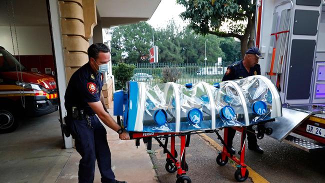 Infection unit specialists push an isolation chamber equipped with a negative pressure filtration system used to transport positive Covid-19 patients in Pretoria. Picture: AFP