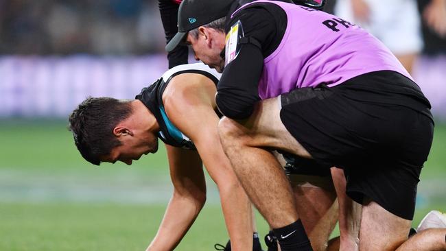 Ryan Burton recovers from being crunched after going back with the flight of the ball on Friday night. Picture: David Mariuz (AAP).