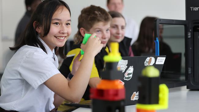 Findon High students (sitting L to R) Sophia Mendoza, 13, Declan Amato, 12, and Amelia Giltrow, 13, during a workshop with 3D printers at Findon High School. Picture: NCA NewsWire / David Mariuz