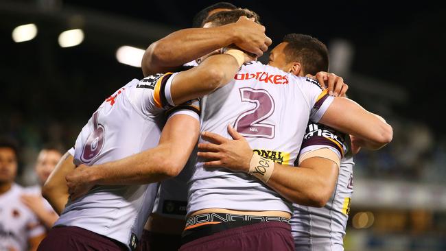 Corey Oates celebrates scoring a try with his Broncos teammates.