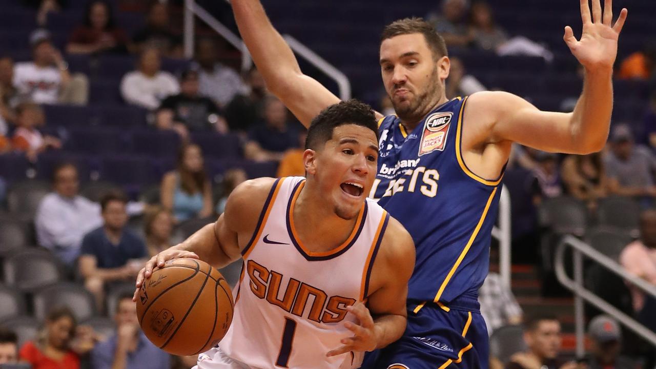 PHOENIX, AZ - OCTOBER 13: Devin Booker #1 of the Phoenix Suns drives the ball past Adam Gibson #1 of the Brisbane Bullets during the second half of the NBA pre-season game at Talking Stick Resort Arena on October 13, 2017 in Phoenix, Arizona. (Photo by Christian Petersen/Getty Images)