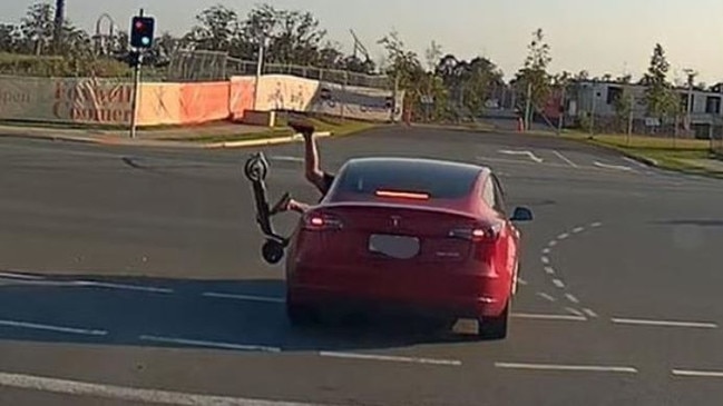 An e-scooter rider is thrown off his ride after smashing into a Tesla. Picture: dashcam Owners Australia