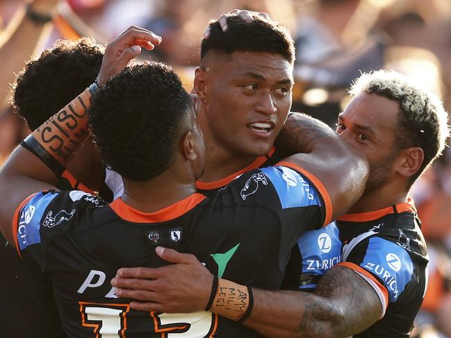 SYDNEY, AUSTRALIA - APRIL 14:  Stefano Utoikamanu of the Tigers celebrates with team mates after scoring a try during the round six NRL match between Wests Tigers and St George Illawarra Dragons at Campbelltown Stadium, on April 14, 2024, in Sydney, Australia. (Photo by Matt King/Getty Images)