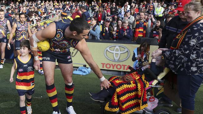 Taylor Walker says hello to young April Williams as the Crows run out before Showdown 47. Picture SARAH REED