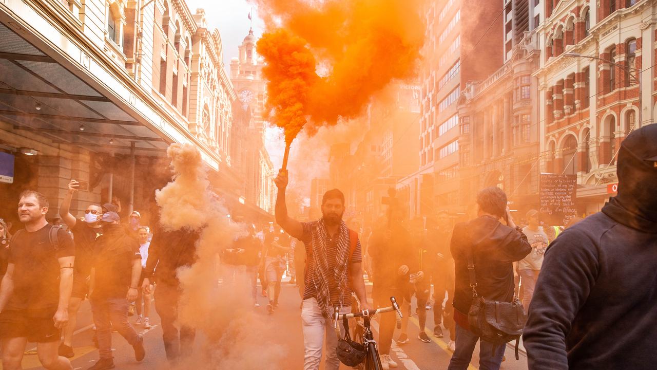 Freedom rally protesters light flares as they marched through the CBD. Picture: NCA NewsWire/Sarah Matray