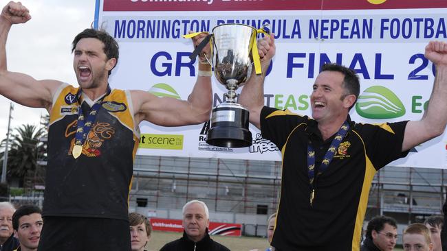 Barry, as captain, and his dad Tony “Bugs” Barry, as coach, lift Frankston YCW’s 2010 premiership cup.