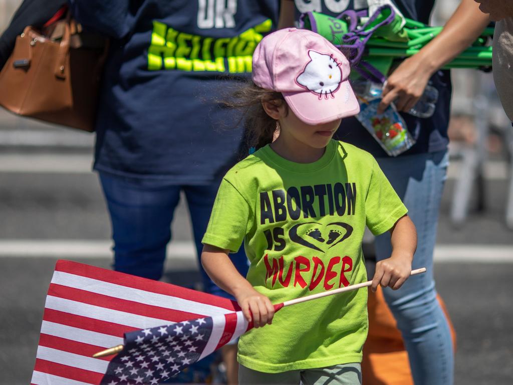 A child with an anti-LGBTQ Christian group wears an anti-abortion shirt and carries an American flag during the annual LA Pride Parade in West Hollywood, California. Picture: AFP