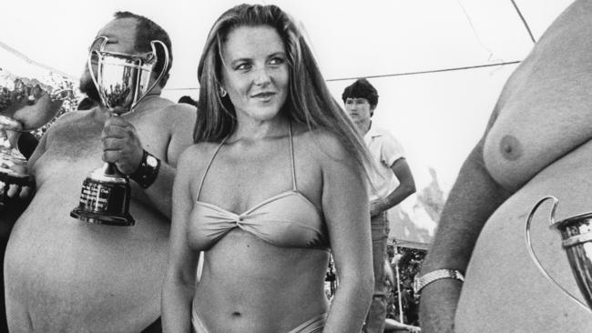 Trophies — and of course a lot of flesh — shown at a beer belly competition at Runaway Bay, circa 1970s.