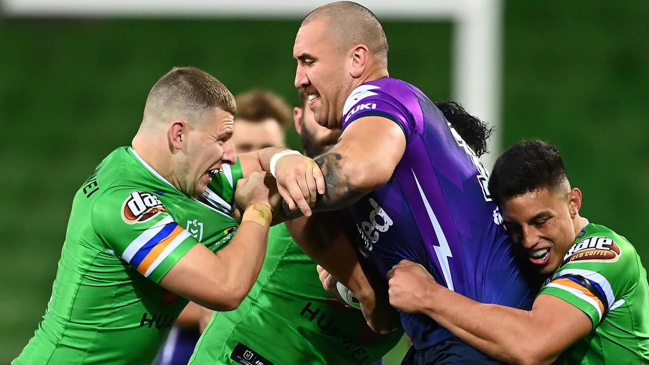 Nelson Asofa-Solomona of the Storm is tackled by the determined Raiders.