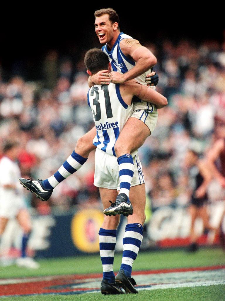 Carey leaps into the arms of Corey McKernan after North’s 1999 Grand Final win. Picture: Michael Klein