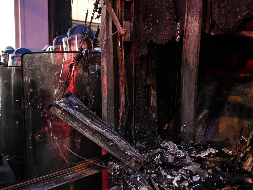 Gendarmes in riot gear stand behind a burnt urban facility during a demonstration as part of a national day of strikes and protests in Paris. Picture: AFP