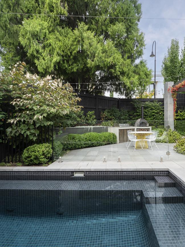 The pool and entertaining area are hemmed with Portuguese laurel.