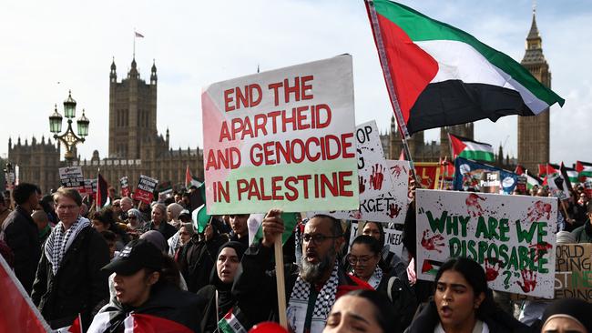 Protesters hold placards and wave Palestinian flags as they walk over Westminster Bridge in London on October 28, 2023, to call for a ceasefire in the conflict between Israel and Hamas. Picture: AFP