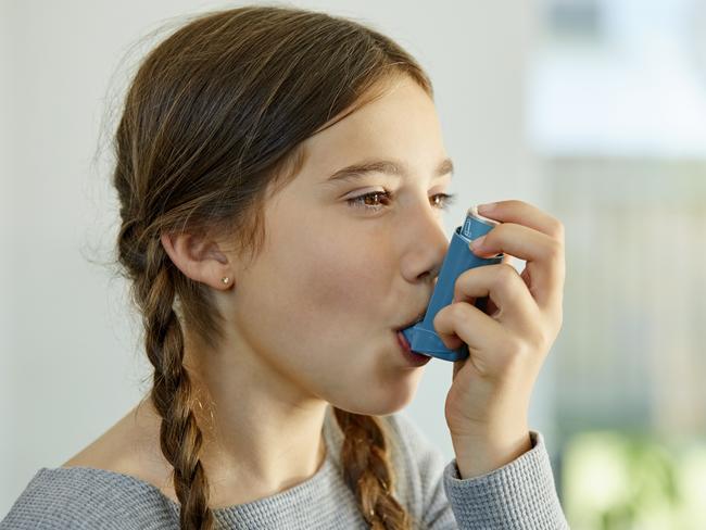 Close-up of girl using asthma inhaler at home. Little girl is suffering from health issues. She is looking away while taking dose. Picture: Istock