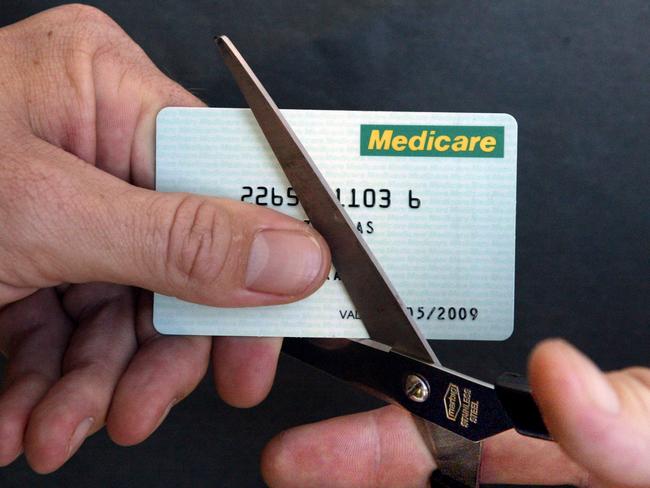 APRIL 28, 2003: Generic photo of cutting up Medicare card with pair of scissors, 28/04/03. Pic Jeff Darmanin.