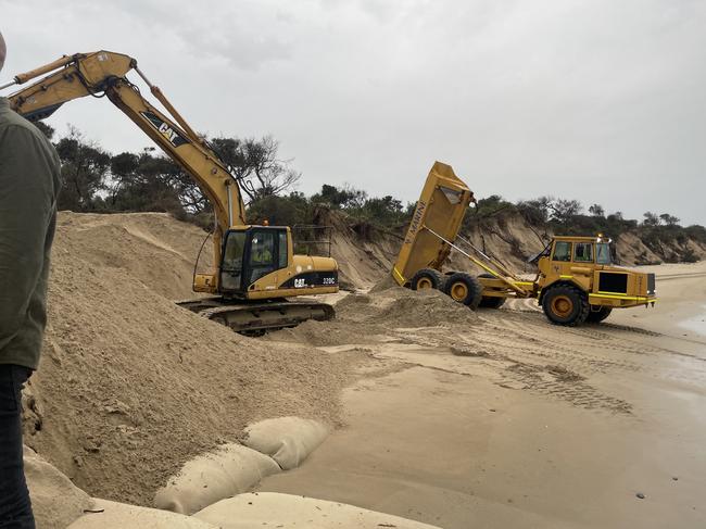 Construction workers assisted by piling more sand on the erosion-affected areas with an excavator and truck. Picture: Jack Colantuono