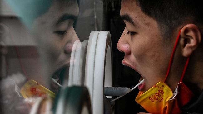 A health worker takes a swab sample from a man to test for the Covid-19 coronavirus in the Jing'an district in Shanghai. Picture: AFP