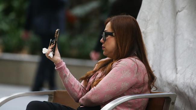 SYDNEY, AUSTRALIA - Newswire Photos - JULY 25 2023: People are seen on their mobile phones during lunch time in the Sydney CBD. Picture: NCA Newswire / Gaye Gerard