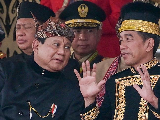 Indonesian President Joko Widodo talks to President-elect Prabowo Subianto (L) following a flag-raising ceremony marking Indonesia's 79th Independence Day at the presidential palace in the future capital Nusantara, in Sepaku, Penajam Paser Utara, East Kalimantan, on August 17, 2024. (Photo by BAY ISMOYO / AFP)