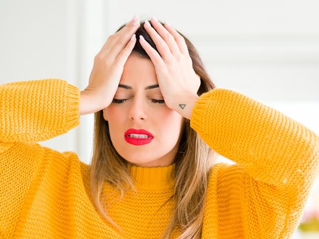 Young beautiful woman drinking a cup of coffee at home suffering from headache desperate and stressed because pain and migraine. Hands on head.Picture: istock