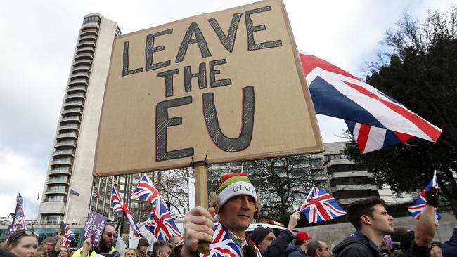 Protesters hold up placards and Union flags as they attend a pro-Brexit demonstration. Picture: AFP