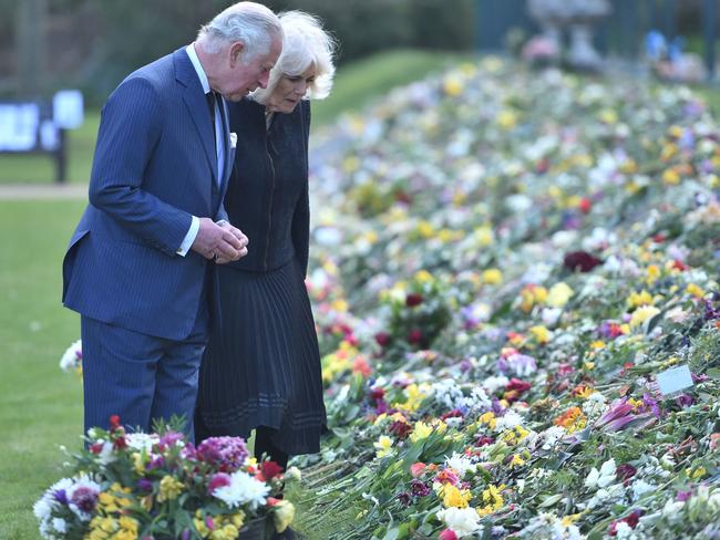 Prince Charles and Camilla view the flowers and messages of condolence left by the public outside Buckingham Palace after Prince Philip’s death. Picture: AFP