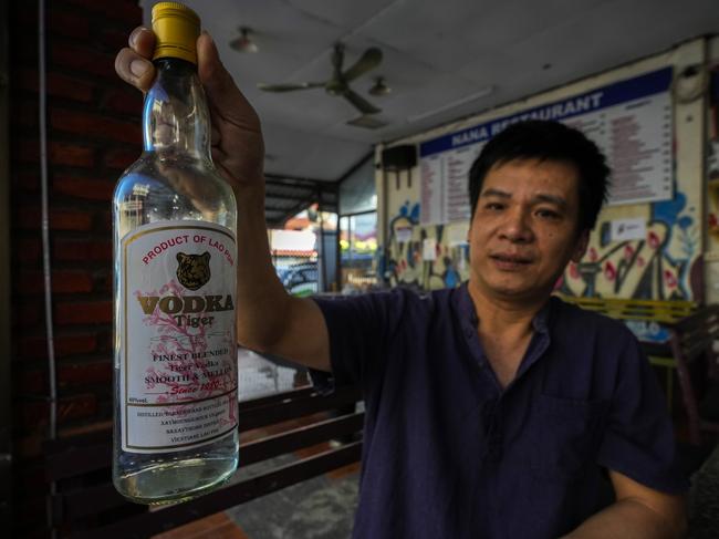 Duong Duc Toan, the manager of Nana Backpack hostel displays a bottle of vodka, in the bar of the hostel in Vang Vieng, Laos, Tuesday, Nov. 19, 2024. (AP Photo/Anupam Nath)