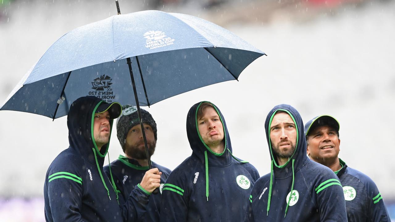 MELBOURNE, AUSTRALIA - OCTOBER 28: Members of the Irish team watch the rain fall during the ICC Men's T20 World Cup match between Afghanistan and Ireland at Melbourne Cricket Ground on October 28, 2022 in Melbourne, Australia. (Photo by Quinn Rooney/Getty Images)