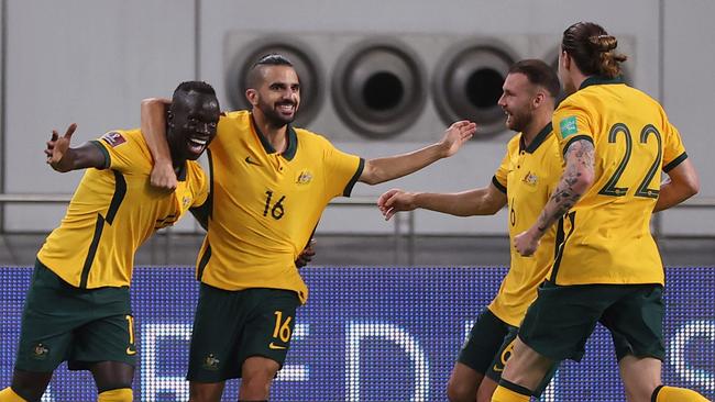 Australia's Awer Mabil (L) celebrates with teammates during the FIFA World Cup Qatar 2022 Asian qualification football match between Australia and China, at the Qatar Sports Club stadium in Doha, on September 2, 2021. (Photo by KARIM JAAFAR / AFP)