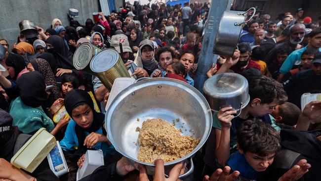 Palestinians gather to receive a hot meal at a food distribution point in the Nuseirat camp for refugees in the central Gaza Strip on May 21, 2025. Picture: AFP