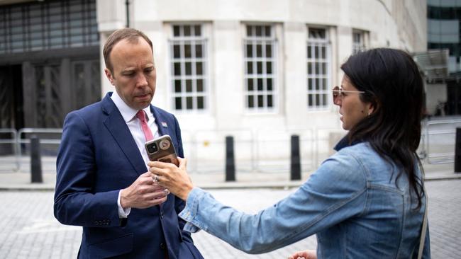 Matt Hancock looks at the phone of his aide Gina Coladangelo earlier this month. Picture: AFP