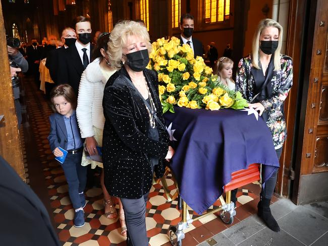 Bert Newton’s coffin is wheeled out of St Patrick’s Cathedral by wife Patti, daughter Lauren, and family. Picture: David Caird