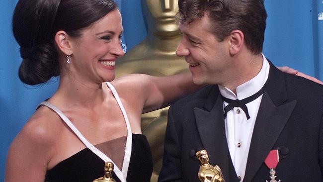 Julia Roberts and Russell Crowe spend a moment in the spotlight backstage after winning Oscars for best actor and actress in a leading role during the 73rd Academy Awards.