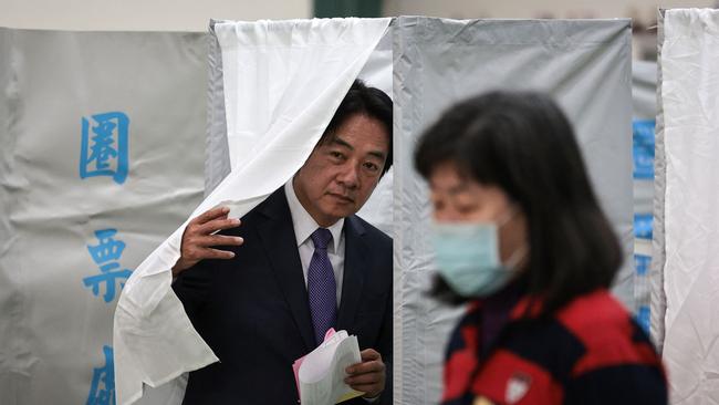 Mr Lai leaves a booth while holding his ballot papers as he votes in the presidential election. Picture: AFP