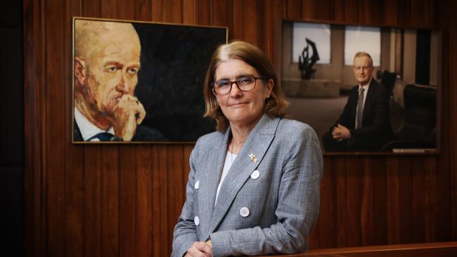 New Reserve Bank governor Michelle Bullock at the RBA offices in Sydney’s Martin Place with portraits of two immediate predecessors, Glenn Stevens, left, and Philip Lowe. John Feder/The Australian.