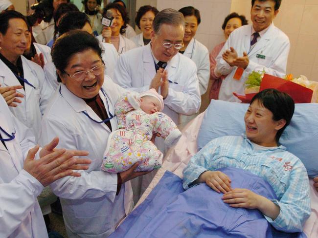 Gu Xiulian, 2ndL, chairwoman of the All-China Women's Federation holding mother Lan Hui's newborn baby at Beijing Maternity Hospital Jan 06 2005. The newborn, is China's 1.3 billionth citizen. (AP /Xinhua, picChen/Shugen) babies staff workers