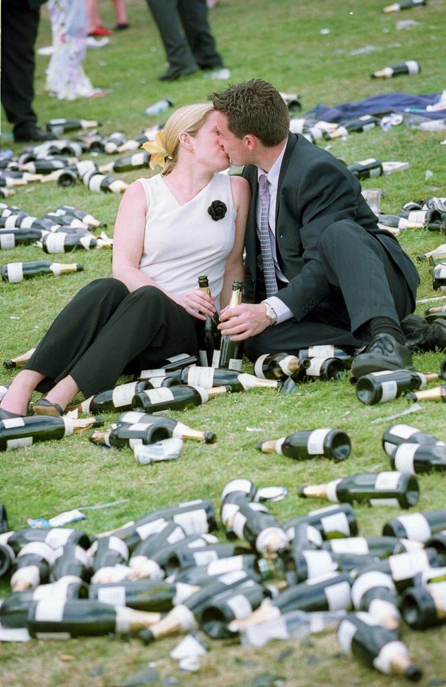 A couple kisses among a sea of empty champagne bottles in 2002.