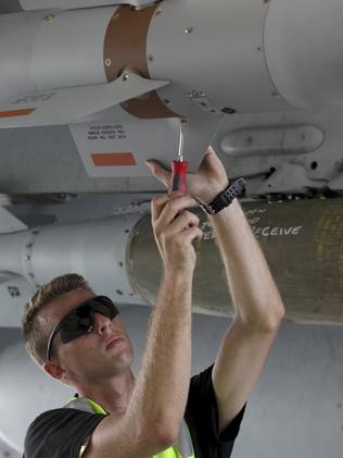 Secure ... RAAF leading Aircraftmen Brad Burrows prepares explosive ordnance on an F/A-18F Super Hornets in the Middle East. Picture: Supplied