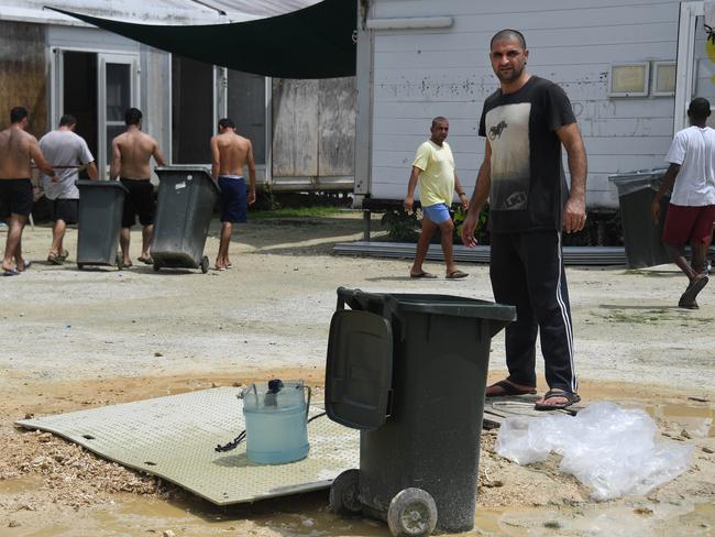 Asylum seekers in the Lombrum detention fill waste bins with water from a makeshift well inside the detention centre. Picture: Brian Cassey