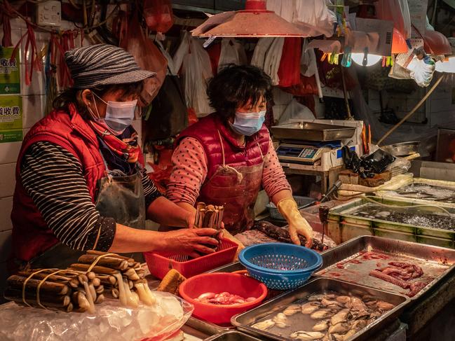 Women working with seafood in Macau, China. Picture: Anthony Kwan/Getty