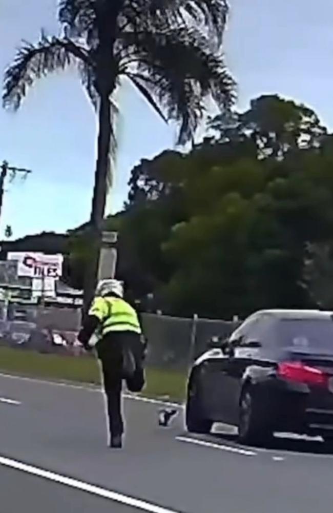 A police officer has thrown an object at a car that failed to follow his directions during a traffic operation in a school zone. Picture: Nine News