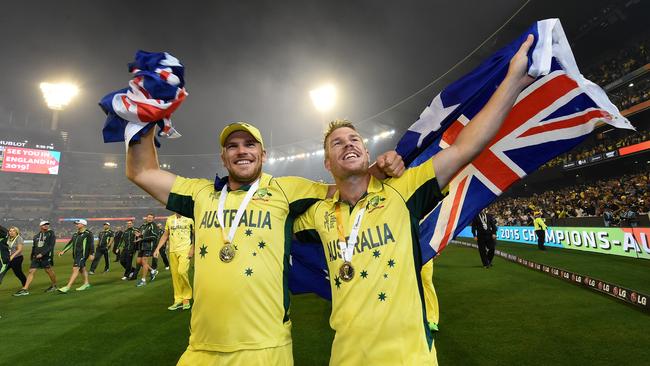 Aaron Finch (left) and David Warner celebrate winning ICC Cricket World Cup trophy during the lap of honour after Australia defeated New Zealand at the MCG in Melbourne, Sunday, March 29, 2015. (AAP Image/Julian Smith) NO ARCHIVING, IMAGES TO BE USED FOR NEWS REPORTING PURPOSES ONLY, NO COMMERCIAL USE WHATSOEVER, NO USE IN BOOKS WITHOUT PRIOR WRITTEN CONSENT FROM AAP