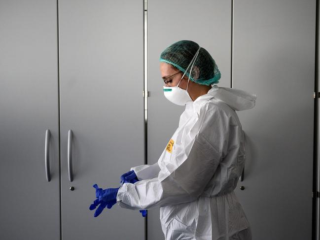 TOPSHOT - A nurse puts on her Personal Protective Equipment (PPE) before starting to work on the preparation of the Intensive care unit in the new Covid-19 Hospital on March 29, 2020 in Verduno, near Alba, Northwestern Italy on the eve of its official opening, as part of the measures taken to fight against the spread of the novel coronavirus. - The hospital have seven beds of intensive care and fifty beds for patients infected by the COVID-19. (Photo by MARCO BERTORELLO / AFP)