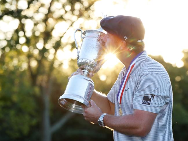 Bryson DeChambeau kisses the championship trophy. (Photo by Jamie Squire/Getty Images)