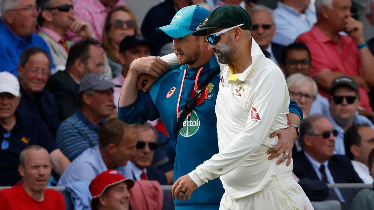 Nathan Lyon is helped off the field after picking up an injury at Lord's. (Photo by Ian Kington / AFP)