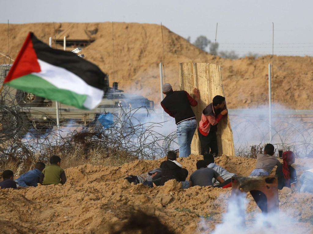 Palestinian protesters use a makeshift shield during a demonstration over illegal settlements near the border with Israel, east of Khan Yunis in the southern Gaza Strip. Picture: AFP