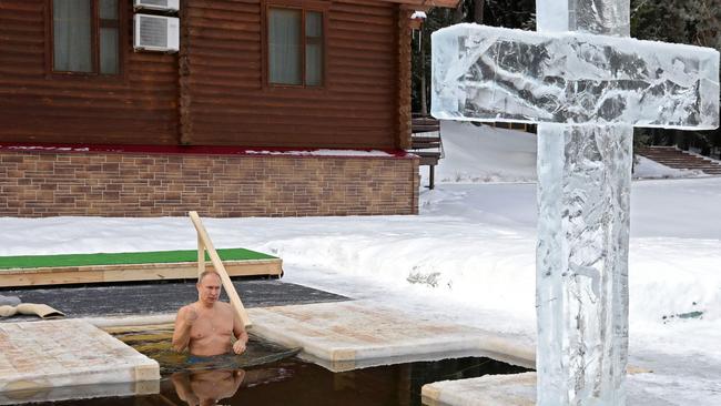 Vladimir Putin crosses himself as he plunges into the icy waters during the celebration of the Epiphany holiday in Moscow. Picture: AFP.