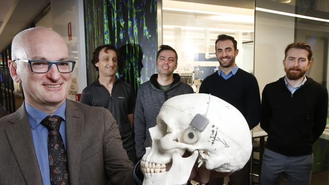 Professor Mark Cook holds the latest iteration of the “Fitbit for the brain” with the development team, including Chris Williams, Yuri Benovitski, Owen Burns and RMIT’s Dave Hill, in the background. Picture: David Caird