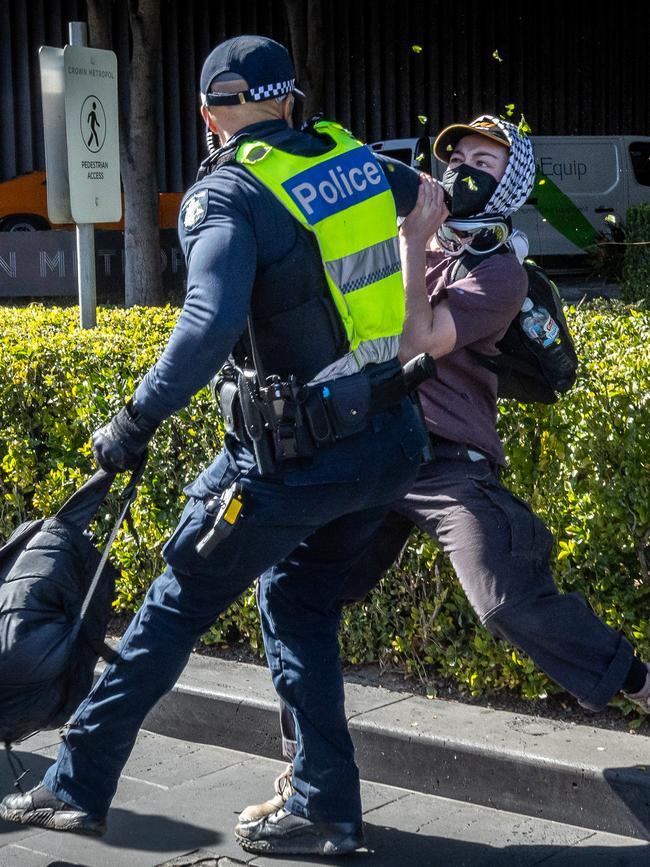 A protester jostles with a police officer. Picture: Jake Nowakowski